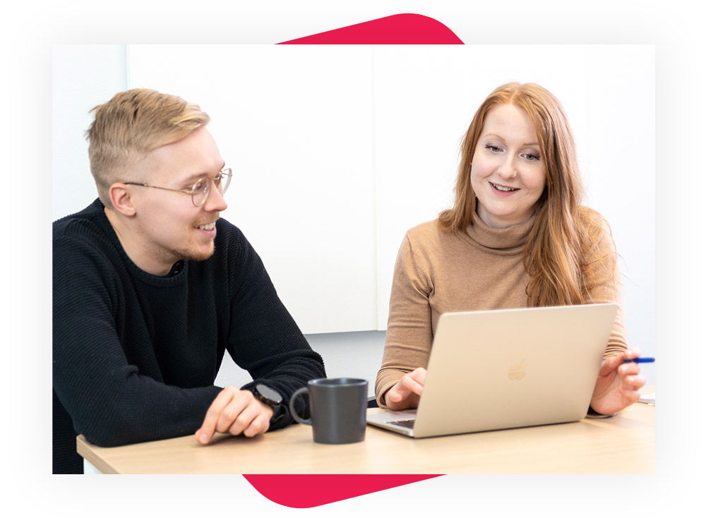 Nainen ja mies työskentelevät yhdessä ja katsovat tietokoneen näyttöä.